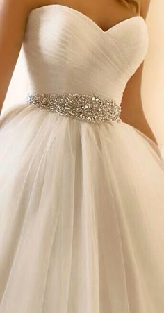 the dress is white and has a crystal belt