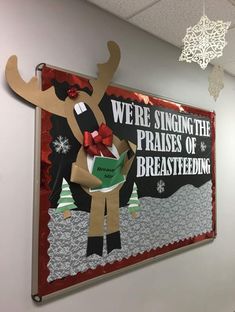 a bulletin board is decorated with reindeers and presents for the holiday season in an office cubicle