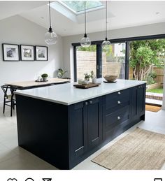 a large kitchen with an island in the middle and lots of lights hanging from the ceiling