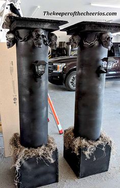 two large black pillars with skulls on them