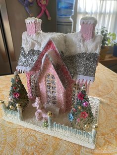 a small pink and silver house on top of a table