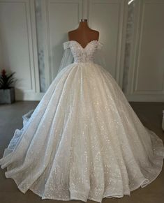 a white wedding dress on display in a room