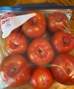 a bag full of tomatoes sitting on top of a wooden table