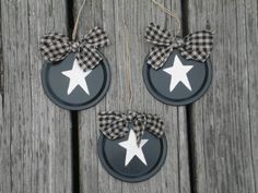 two black and white christmas ornaments hanging on wooden planks with gingham bows