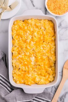 a casserole dish with cheese on top and two forks next to the casserole