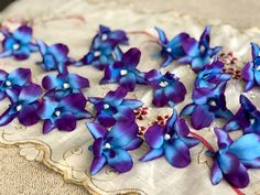 purple and blue flowers sitting on top of a white doily