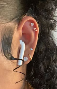 a woman with ear piercings on her ears and the word i is written on it