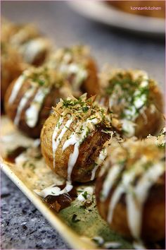 some food is sitting on a plate with white sauce and sprinkled toppings