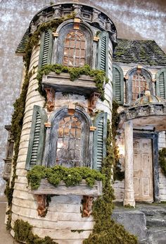 a doll house with moss growing all over it's walls and windows on the outside