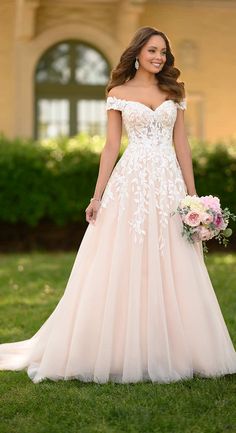 a woman in a wedding dress standing on the grass