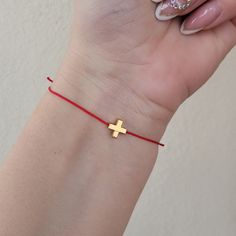 "This minimalist cross bracelet features an elegant 18K gold plated cross charm on an adjustable Kabbalah string.  The simplicity of the design allows the beauty and symbolism of the cross to shine through, making it a perfect accessory for those who prefer a subtle and understated style.  The adjustable string ensures a comfortable and secure fit for all wrist sizes. The bracelet is also imbued with religious significance, as it is designed as a \"make a wish\" bracelet that allows wearers to connect with their faith and make a wish while wearing it.  Perfect gift for your bff, your bridesmaids, or a special person in your life.  8 mm gold plated cross,moves loosely from imitate silk polyester string.  The bracelet is adjustable from 7-8 inches, it closes and opens through sliding knots. Elegant Adjustable Cross Bracelet, Gold Cross Bracelet For Baptism, Adjustable Brown Cross Bracelet, Silver Cross Bracelet, Spiritual Style, Pink Adjustable Cross-shaped Bracelets, Dodger Blue, Red Gift, Wish Bracelets, Cross Bracelet