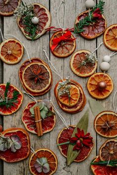 an assortment of orange slices are arranged on a wooden table with christmas decorations and baubles