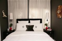 a bed with white sheets and black pillows