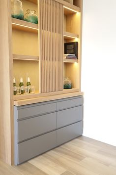 an empty room with wooden shelves and glassware on the counter top in front of it