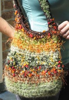 a woman holding a multicolored handbag in her hands