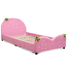 a pink bed with green leaves on the headboard and foot board, sitting in front of a white background