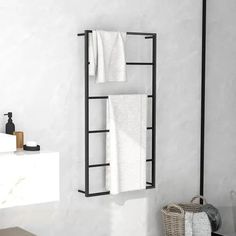 a towel rack with two towels hanging from it's side in a white bathroom