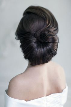 the back of a woman's head with her hair in a bun