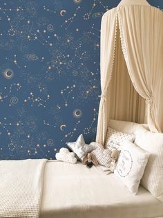 a child's bedroom with blue wallpaper and white bedding, stars in the sky