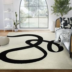 a white rug with black letters on it in a living room next to a large window