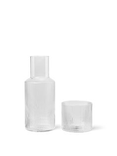 two clear glass vases sitting next to each other on a white surface with no one around them