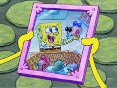 spongebob is holding up a picture frame with other cartoon characters in the background