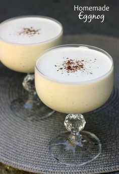 two glasses filled with pudding sitting on top of a glass plate next to each other