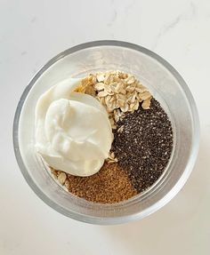 ingredients in a bowl for making granola and yogurt on a white surface