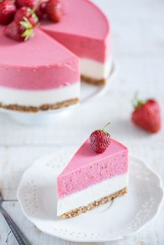 two slices of strawberry cheesecake on white plates