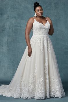 a woman in a wedding dress posing for the camera with her hands on her hips