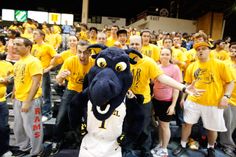 a man in a mascot costume standing next to a group of people wearing yellow shirts