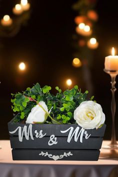 a table with candles and flowers on it in front of a sign that says mr & mrs