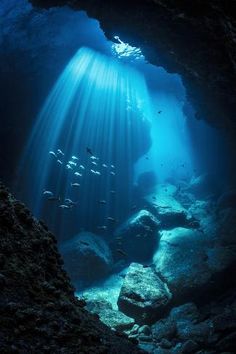 an underwater cave with sunlight streaming through the water