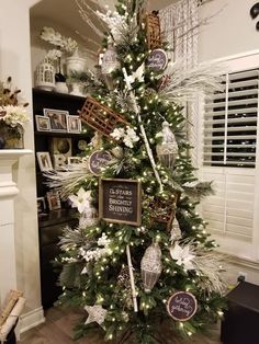 a decorated christmas tree in a living room with white and silver decorations on the top