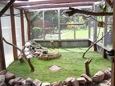 the inside of a greenhouse with grass and rocks