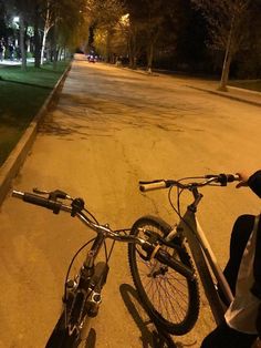 a bicycle parked on the side of a road at night