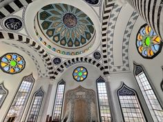 the interior of an ornate building with stained glass windows