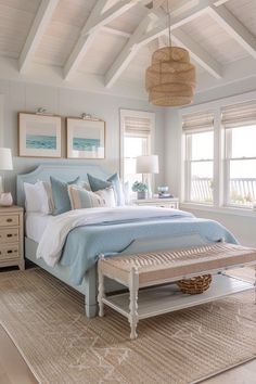 a bedroom with white and blue bedding, two nightstands and a bench in front of the bed