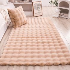 a bed room with a large fluffy rug on the floor and a teddy bear next to it