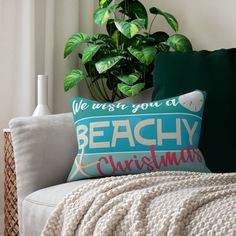 a couch with a pillow on it next to a potted plant