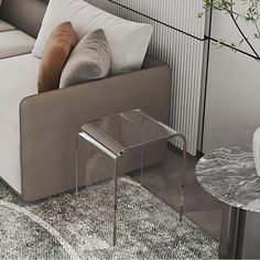 a white couch sitting next to a glass table on top of a carpeted floor