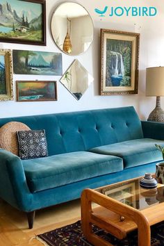 a living room with blue couches and pictures on the wall above them, along with a coffee table