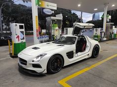 a white sports car parked at a gas station