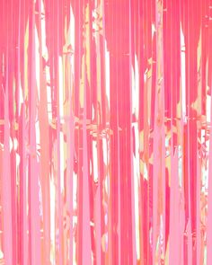 an abstract painting with pink and yellow strips hanging from it's sides in front of a blue sky