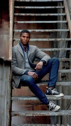 a man sitting on top of a set of stairs next to a metal staircase case