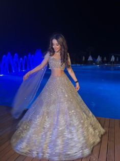 This lehenga set is hand embroidered with all-over sequin, crystal, and cutdana work on a nude gold net base. Paired with a crystal-embellished cold shoulder blouse with tassel detailing and an attached drape.DELIVERY TIMEPlease allow 8-12 weeks for your outfit to arrive.FABRIC DETAILSNetProfessional cleaning only.