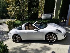 a white sports car parked in front of a house