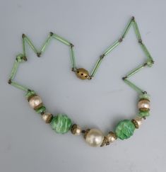 "An early piece. Very special. Peking Glass, depicting Jade gemstone. 15\" in length so more of a choker. Two central drizzle/stepped/ridged beads, flanked with faux pearls with caplets. One caplets missing on the small pearl. Bugle beads forming the 'chain'. A couple of the bugle beads have nicks towards the openings, one closest to clasp and the other 3 beads along from the centre. Ornate filigree ball clasp." Vintage Adjustable Necklace With Spacer Beads, Adjustable Vintage Necklace With Spacer Beads, Vintage Beads For Jewelry Making, Vintage Czech Glass Beaded Necklace, Vintage Necklace With Bead Caps And Round Beads, Vintage Necklaces With Round Beads And Bead Caps, Vintage Beaded Necklace With Bead Caps, Vintage Necklaces With Bead Caps And Round Beads, Vintage Green Glass Beaded Necklaces