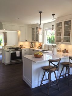 a kitchen with two stools and an island in front of the stove top oven