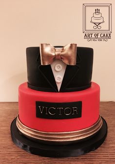 a red and black cake with a tuxedo on it's top tier